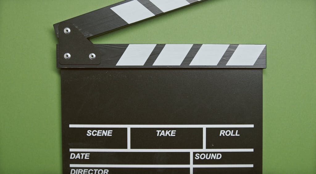 A classic film clapperboard on a green surface, essential for movie scenes.